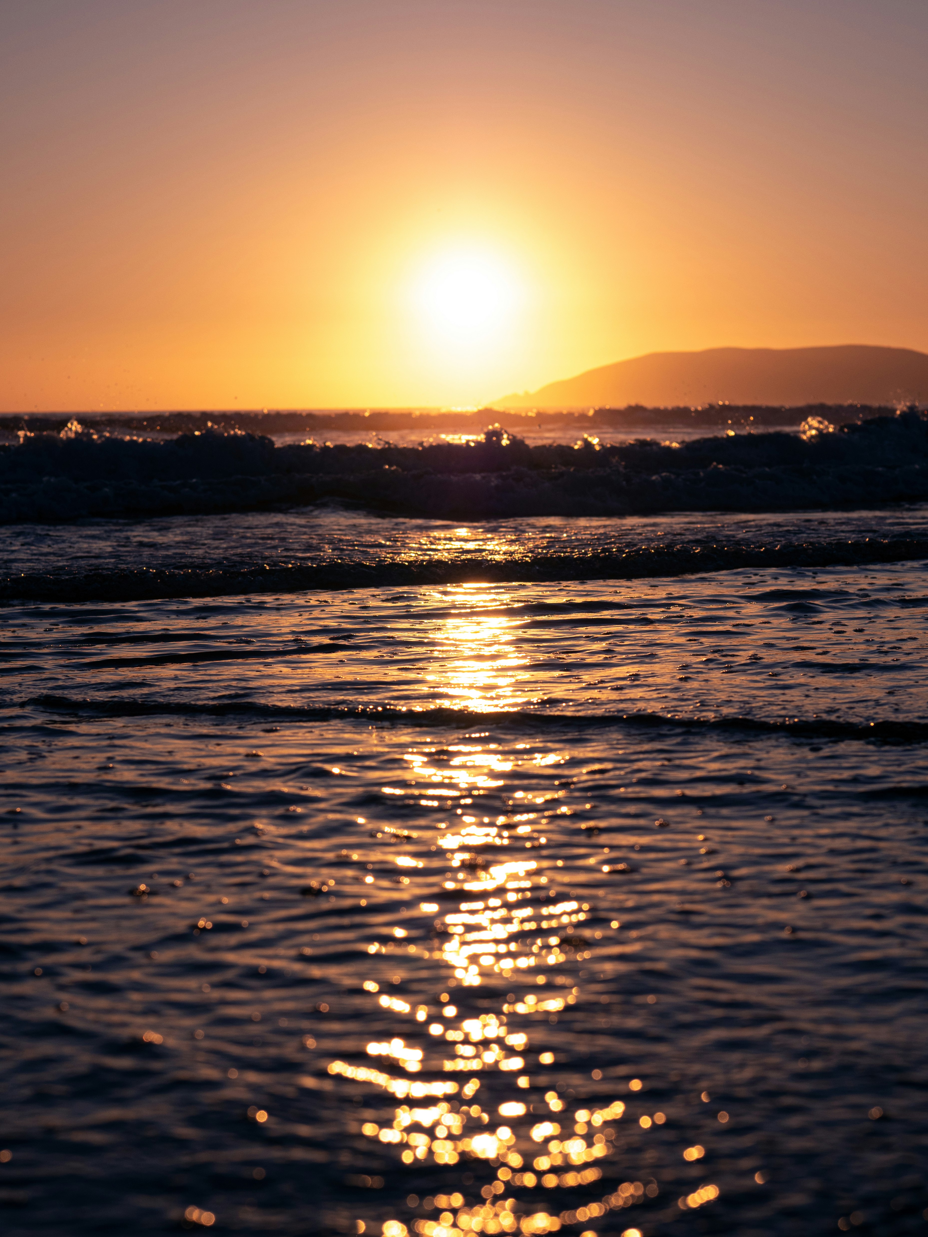 waves crashing on shore during golden hour